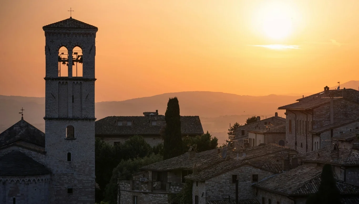 Assisi Umbria Italy rooftops and bell tower at golden hour — luxury pilgrimage Italy Charme