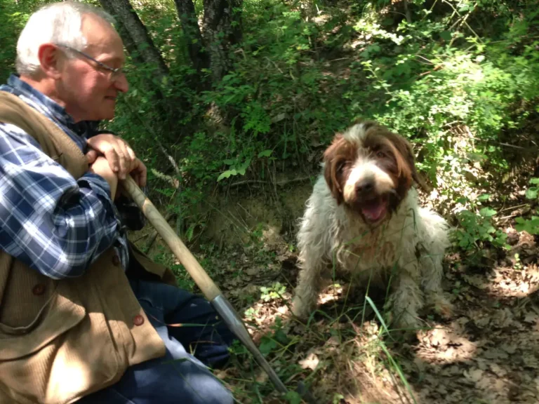 Truffle hunter resting with his dog in the woods