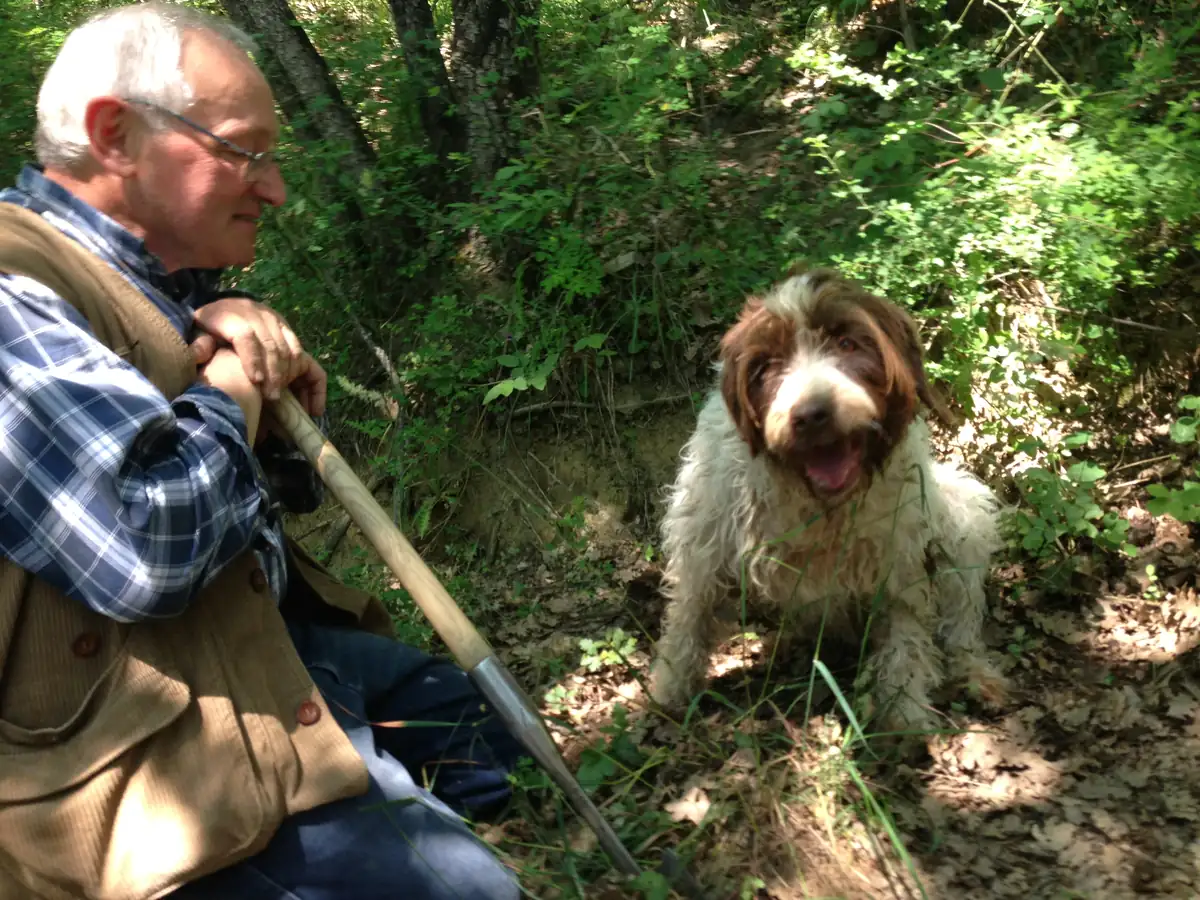 Truffle hunter resting with his dog in the woods