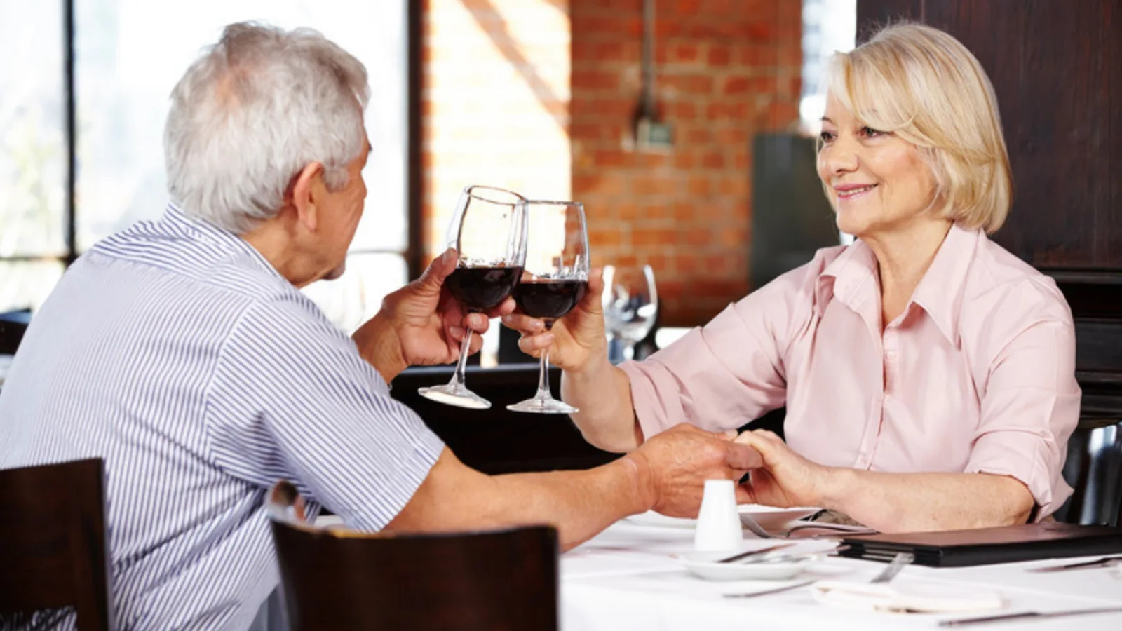 Senior couple toasting with red wine at lunch in a restaurant