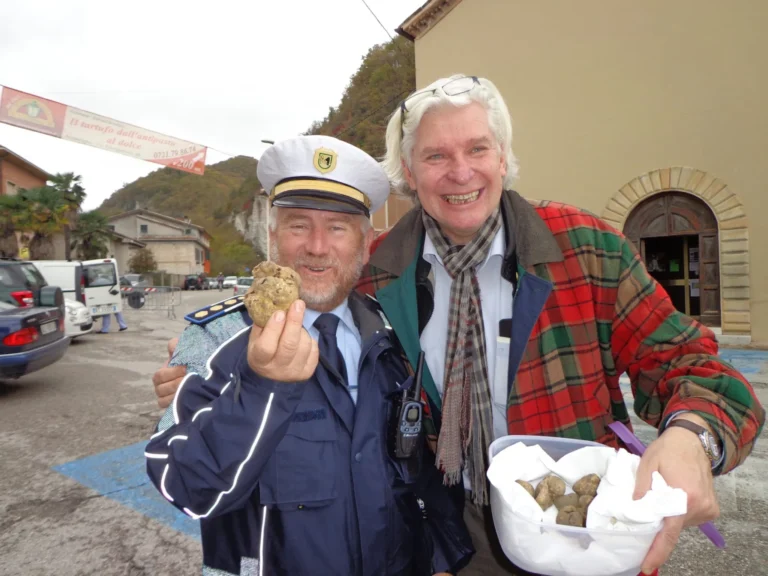 A truffle hunter holding up a truffle at a truffle fair in Le Marche