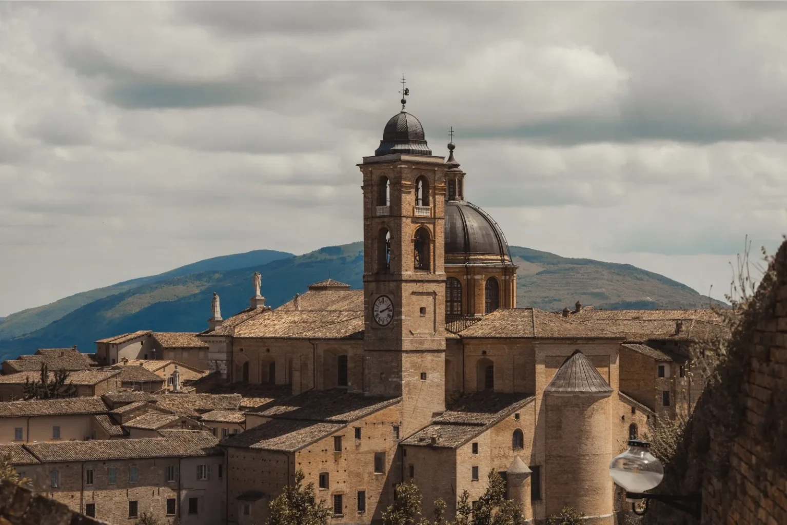The bell tower and dome of Urbino Cathedral above the rooftops of the old town